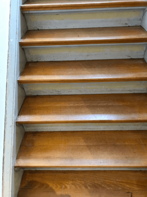 Eine Nahaufnahme einer Holztreppe mit weißen Stufen.