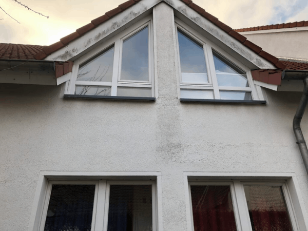 Ein weißes Haus mit einem dreieckigen Fenster