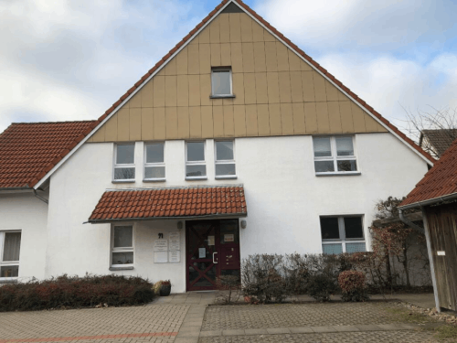 Ein großes weißes Gebäude mit einem braunen Dach