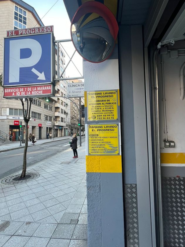 Una señal de estacionamiento está en el costado de un edificio.