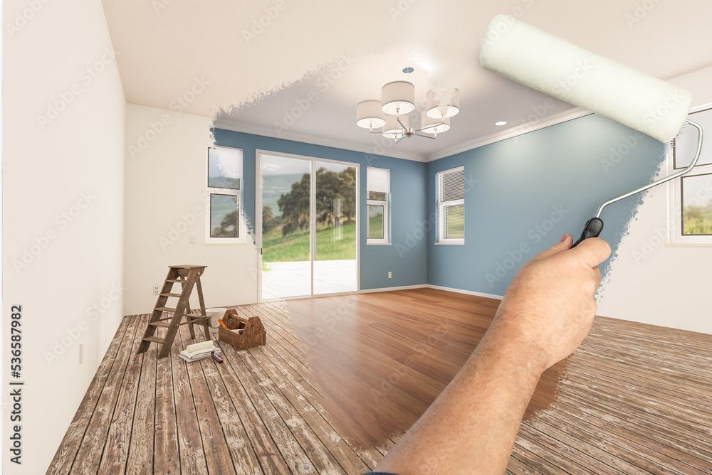 Peinture à la main d'une pièce en bleu avec un rouleau à peinture ; parquet, escabeau et fenêtre.