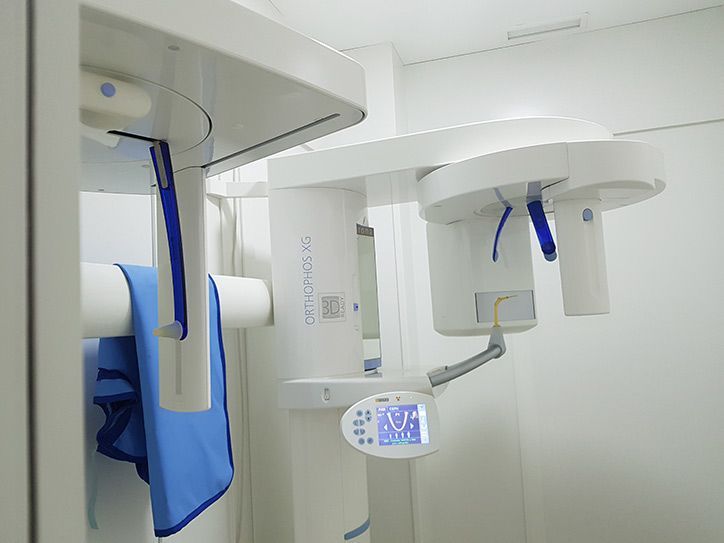 Una máquina de rayos X dental está en una habitación blanca.