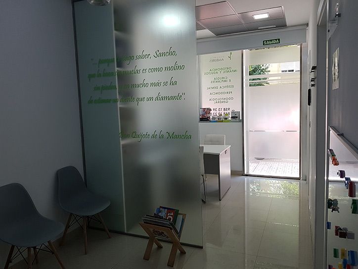 Una sala de espera con sillas, un escritorio y una puerta.
