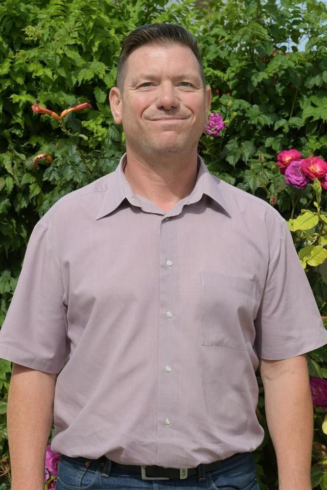 Dirigeant de la société souriant devant un buisson