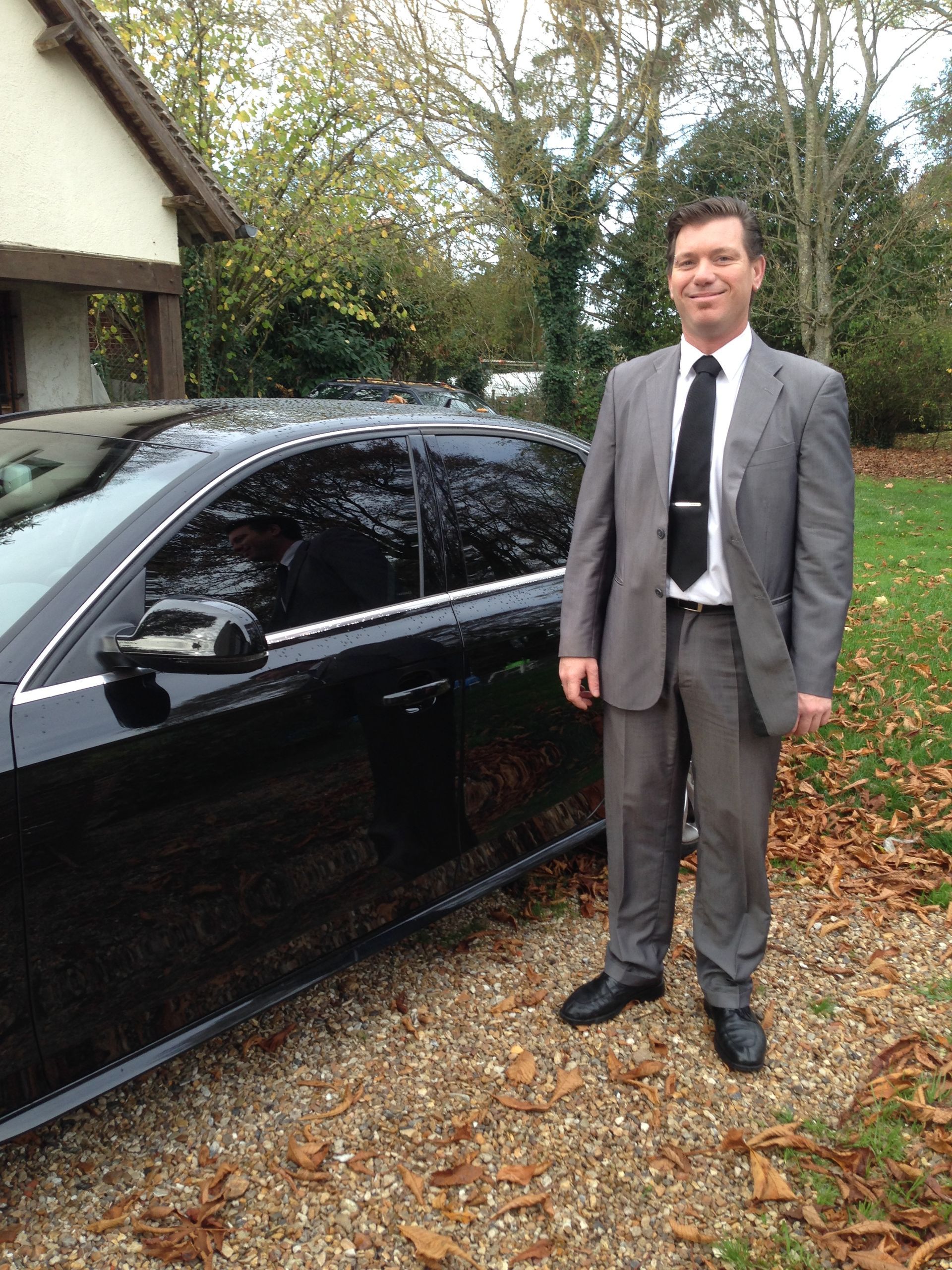 Patron de la société devant un véhicule