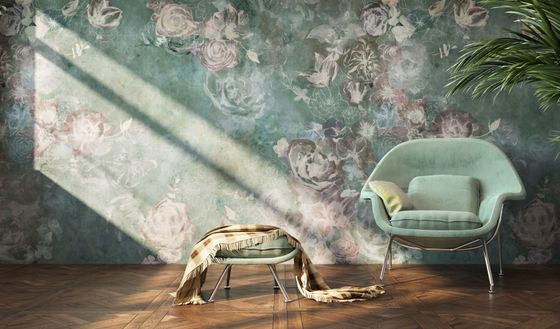 Fauteuil menthe et couverture drapée dans une pièce ensoleillée aux tons fleuris et au parquet.