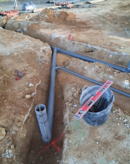 Un sitio de construcción con un balde de cemento y un nivel.