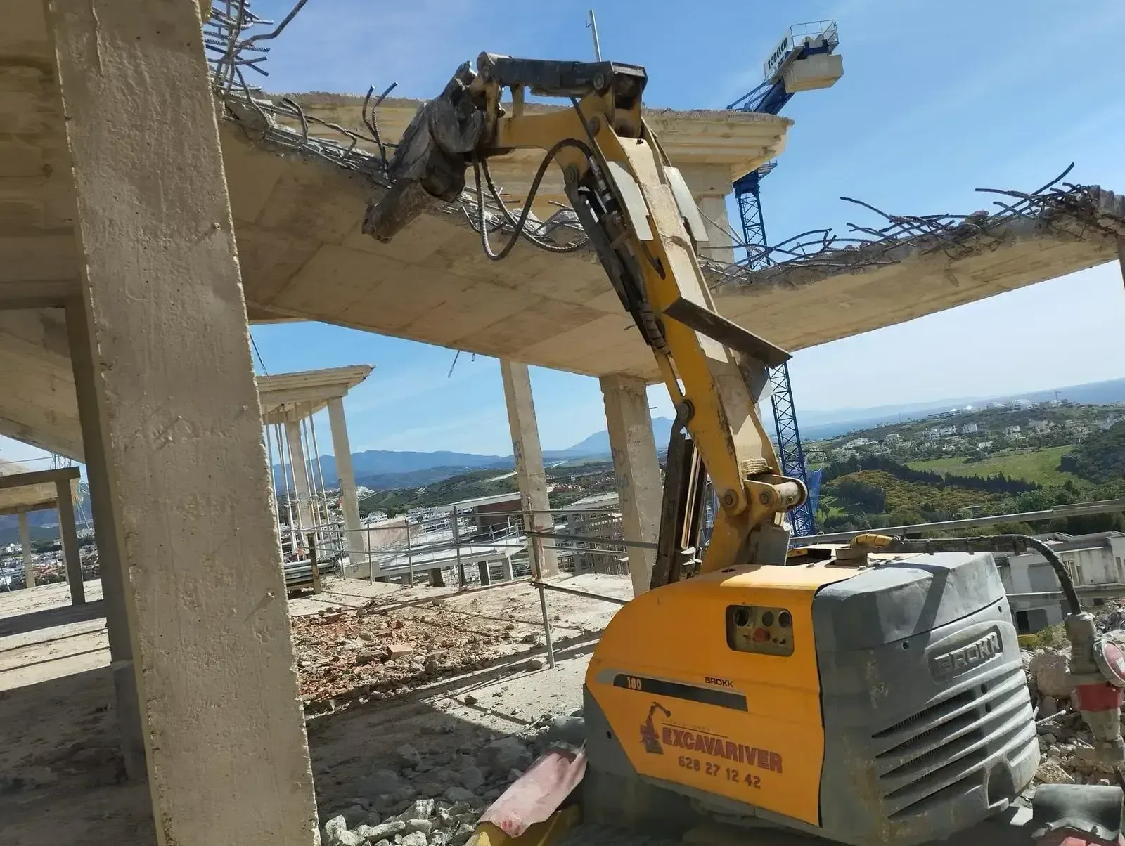 Se está utilizando una excavadora amarilla para demoler un edificio.