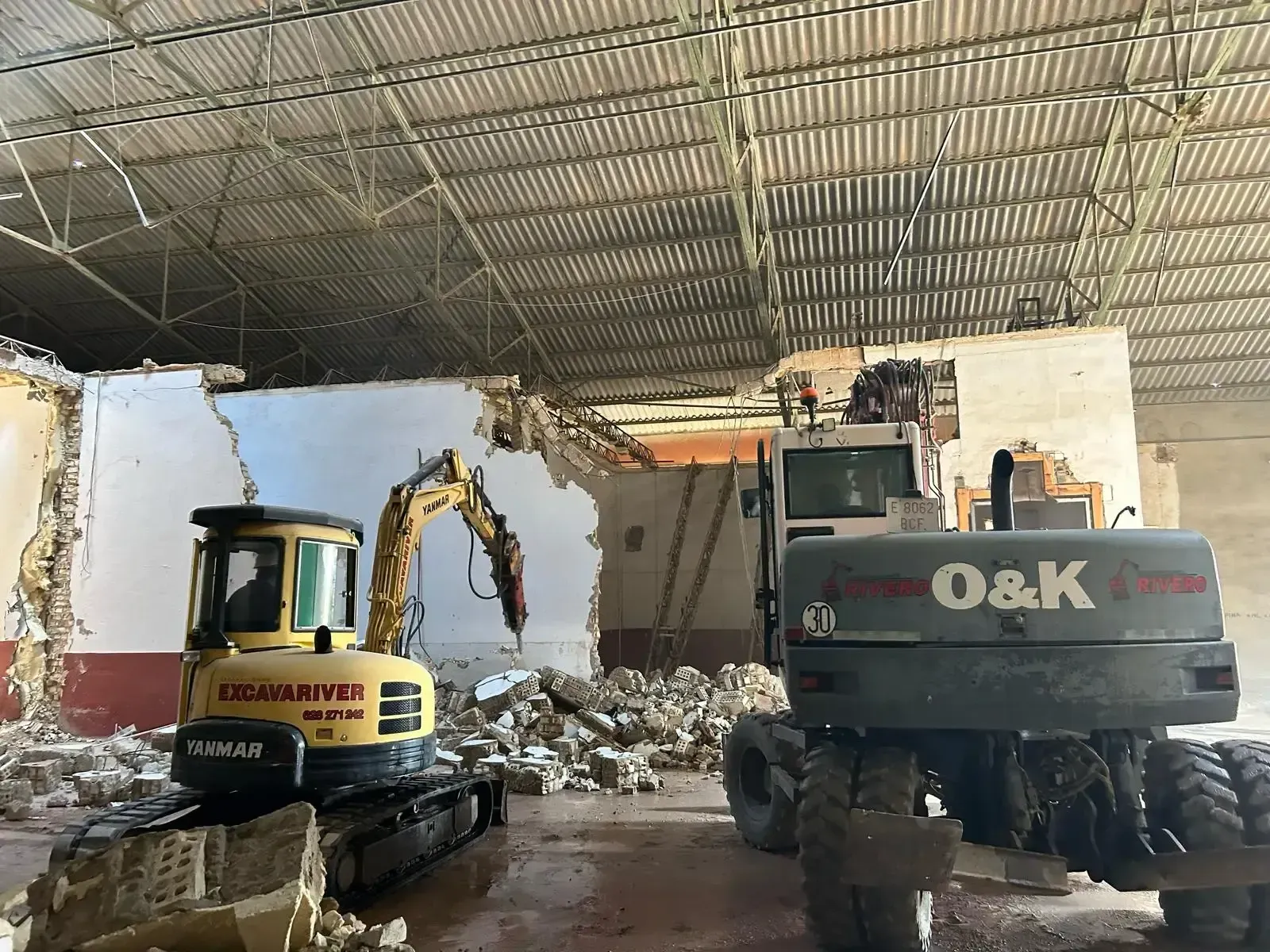 Se están utilizando dos tractores O&K para demoler un edificio.