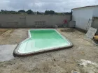 Se está construyendo una piscina verde en un patio trasero.