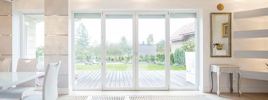 Porte-fenêtre blanche donnant sur terrasse en bois