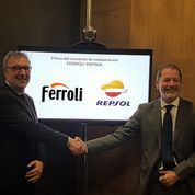 Dos hombres se dan la mano delante de una pantalla con los logotipos de Ferroli y Repsol.