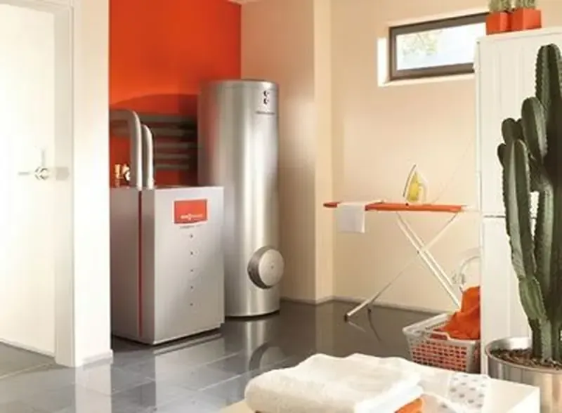 Lavandería con sistema de calefacción y cisterna. Interior en gris, naranja y blanco con ropa de cama y un cactus.