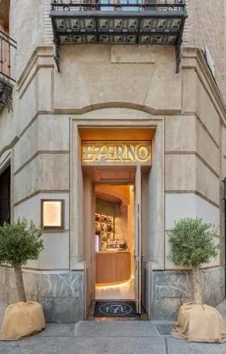 La entrada a un restaurante con árboles delante.