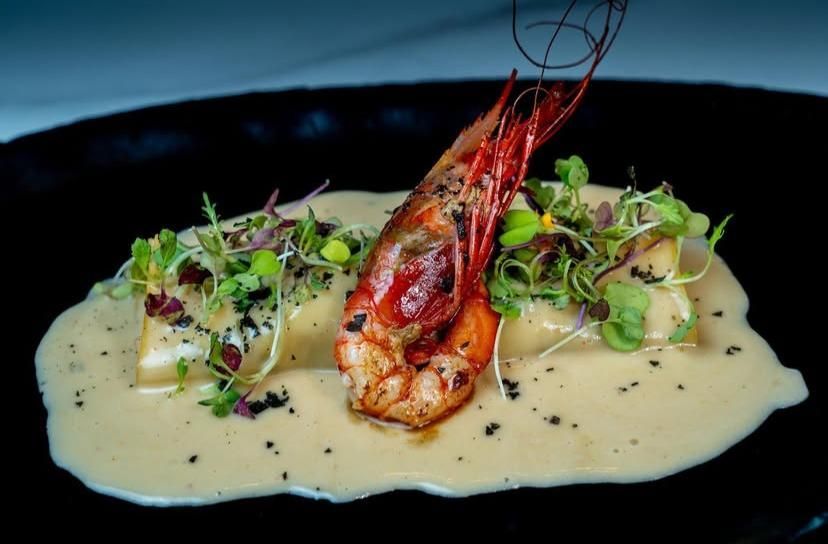 Un primer plano de un plato de comida con camarones y salsa.