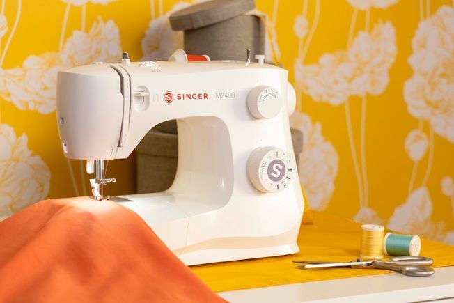 Una máquina de coser Singer blanca sobre un fondo blanco