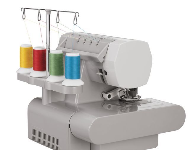 Una máquina de coser Singer con tres carretes de hilo colgando de ella.