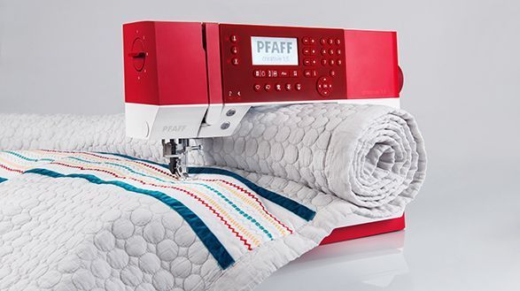 Una máquina de coser roja y blanca está sobre una mesa.