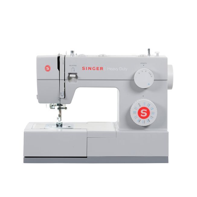 Una máquina de coser Singer está colocada sobre una superficie blanca.