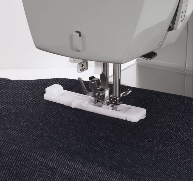 Una máquina de coser Singer está colocada sobre una superficie blanca.