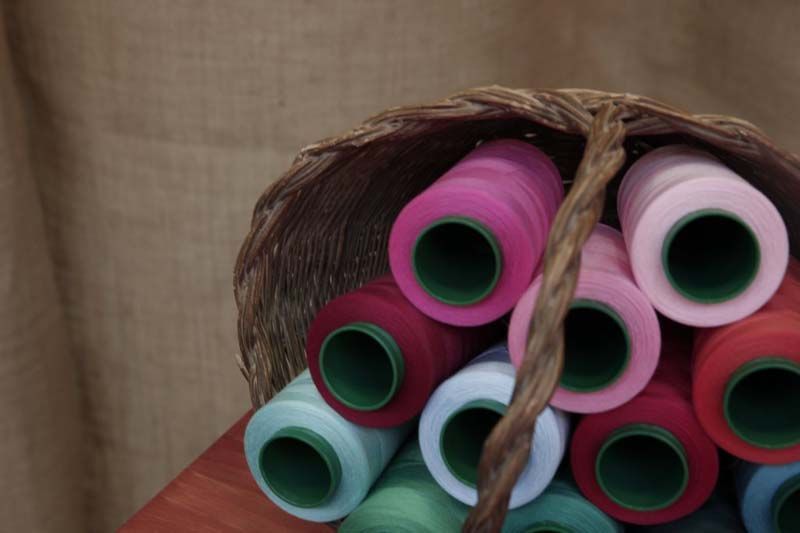 Una cesta llena de carretes de hilo de diferentes colores