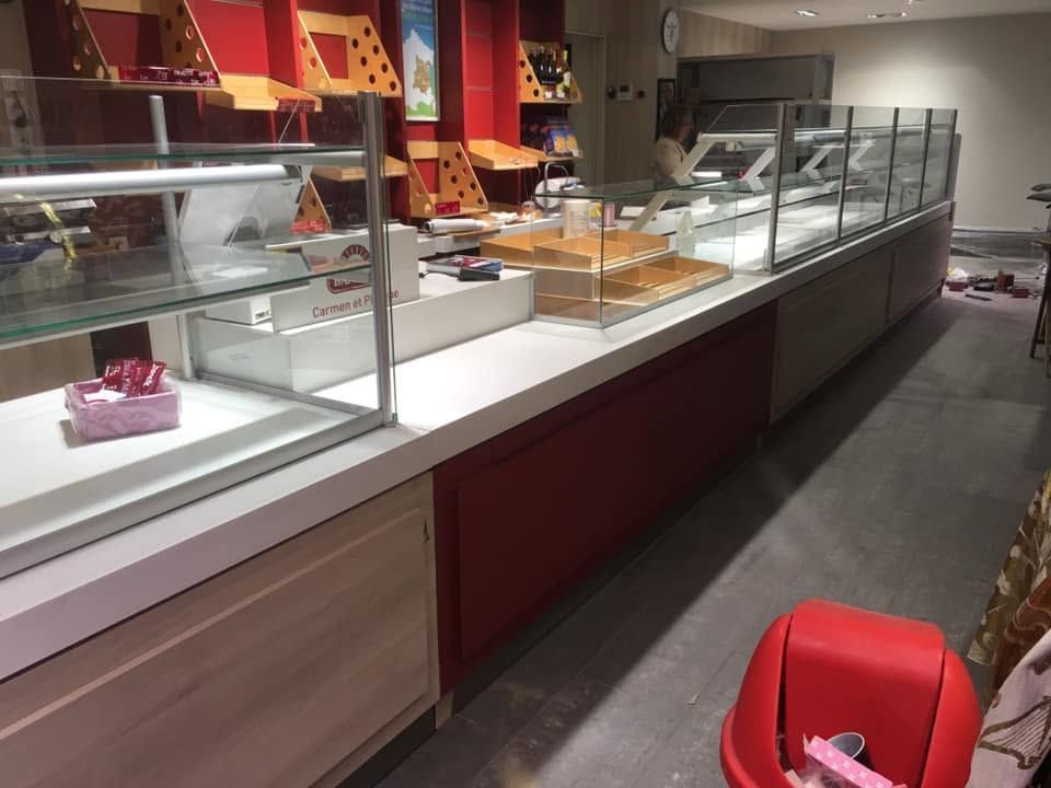 Vitrines de boulangerie vides et comptoir de service dans un intérieur de magasin lumineux.