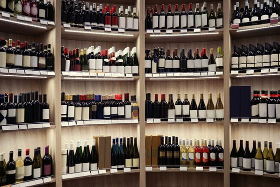 Des étagères remplies de bouteilles de vin assorties dans une vitrine de magasin.