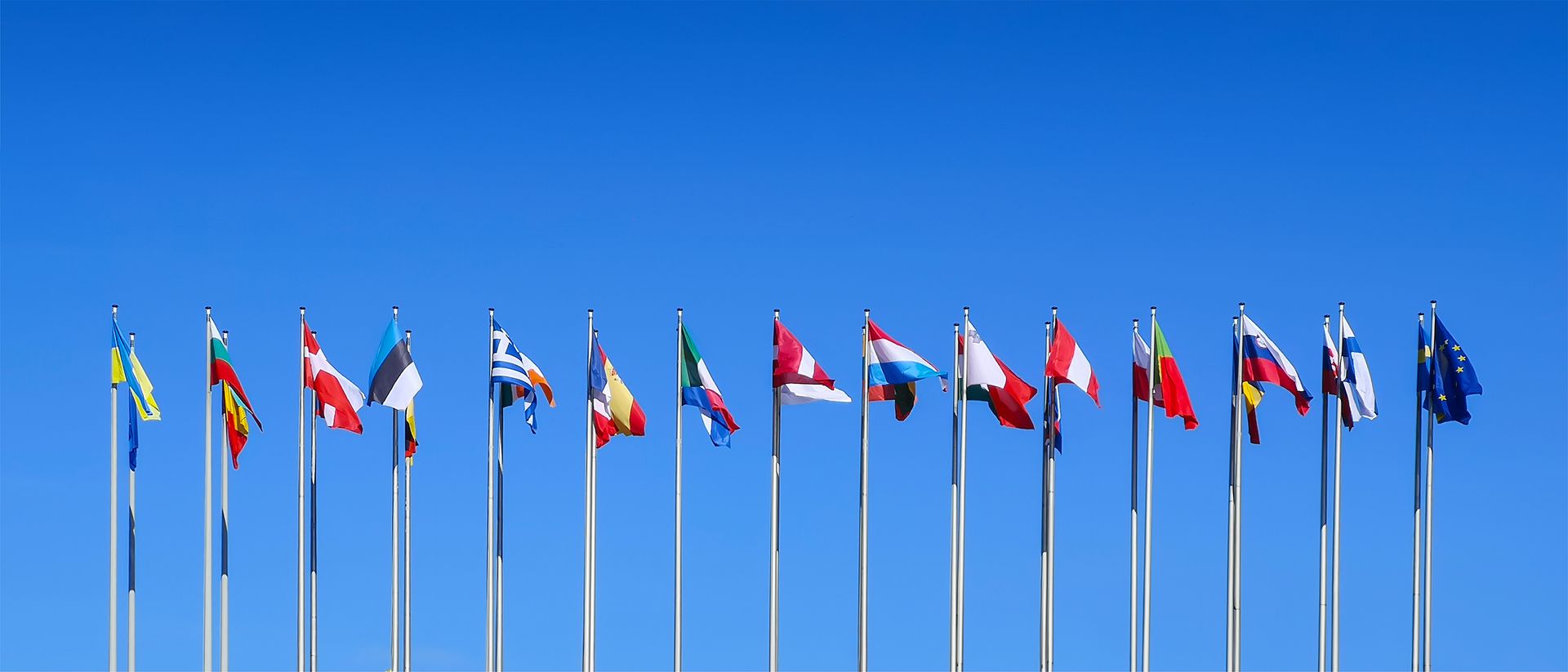 Le bâtiment du Parlement européen, avec les drapeaux de différentes nations flottant devant.