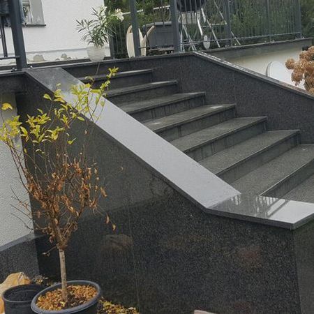 Eine große Eingangstreppe komplett aus grauem Naturstein