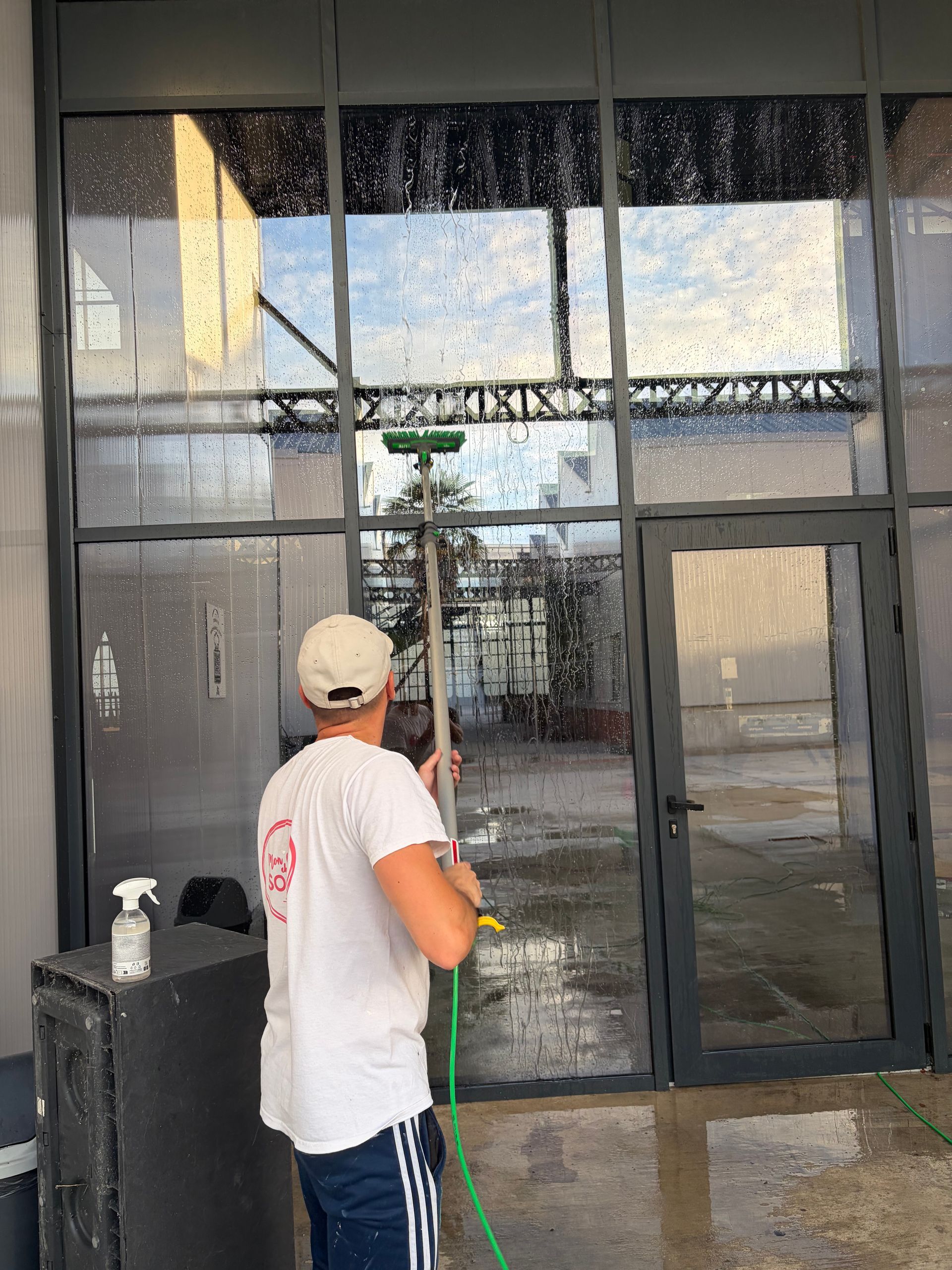 Façade fermée avec un auvent à rayures jaunes et blanches et une porte en bois entre deux vitrines.