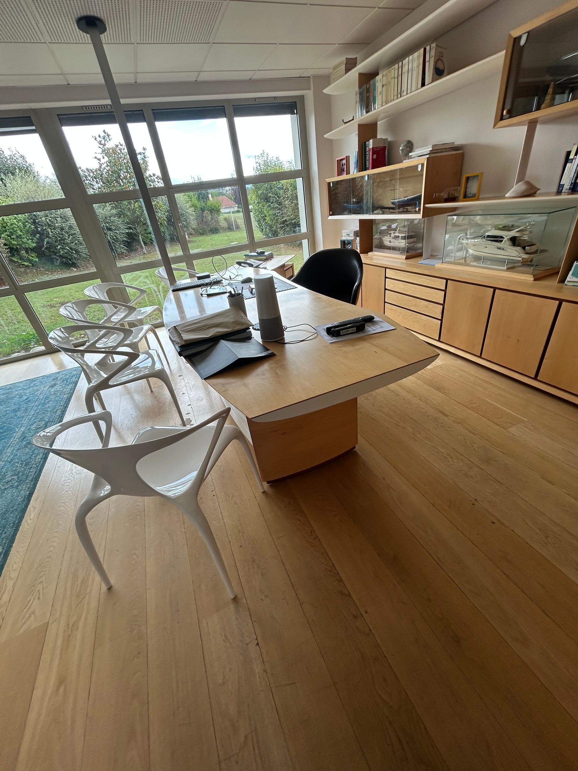 Salon moderne avec table blanche, chaises rouges et mur peint abstrait
