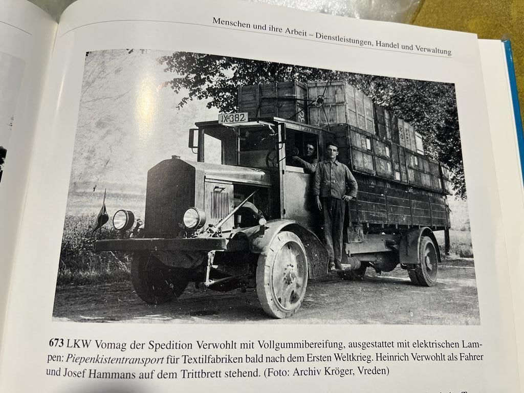 Ein Schwarzweißfoto eines Lastwagens mit einem Mann, der in der Tür steht.