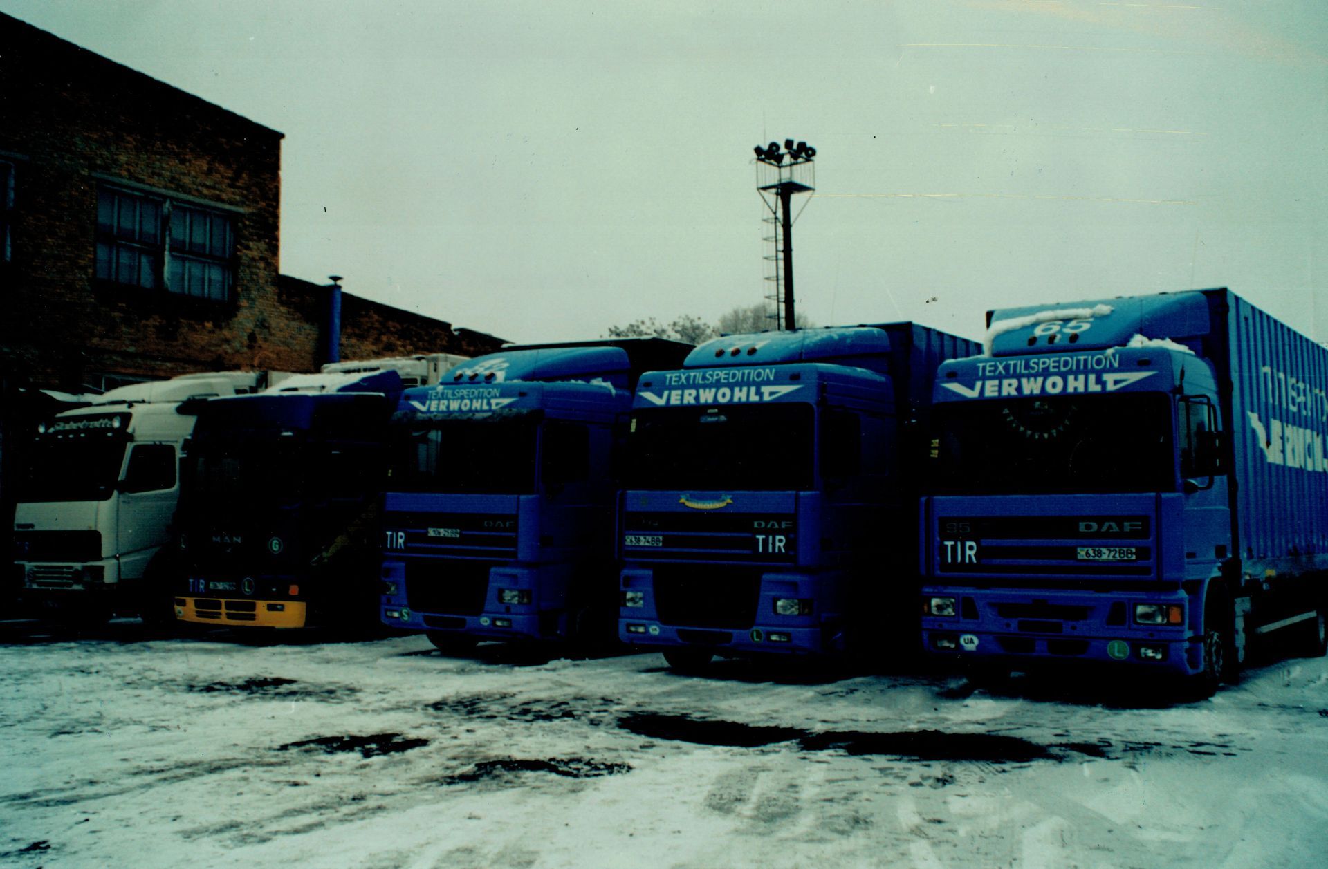 Eine Reihe blauer Lastwagen parken im Schnee