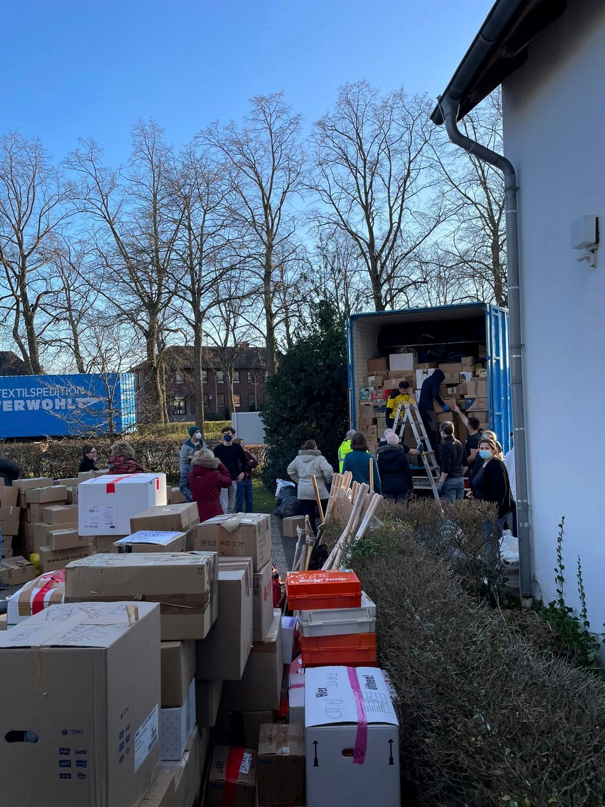 Eine Gruppe von Menschen lädt Kisten in einen Lastwagen.