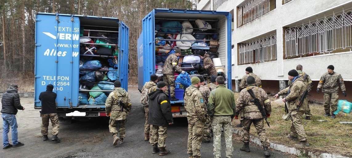 Eine Gruppe Soldaten steht vor einem blauen Lastwagen.