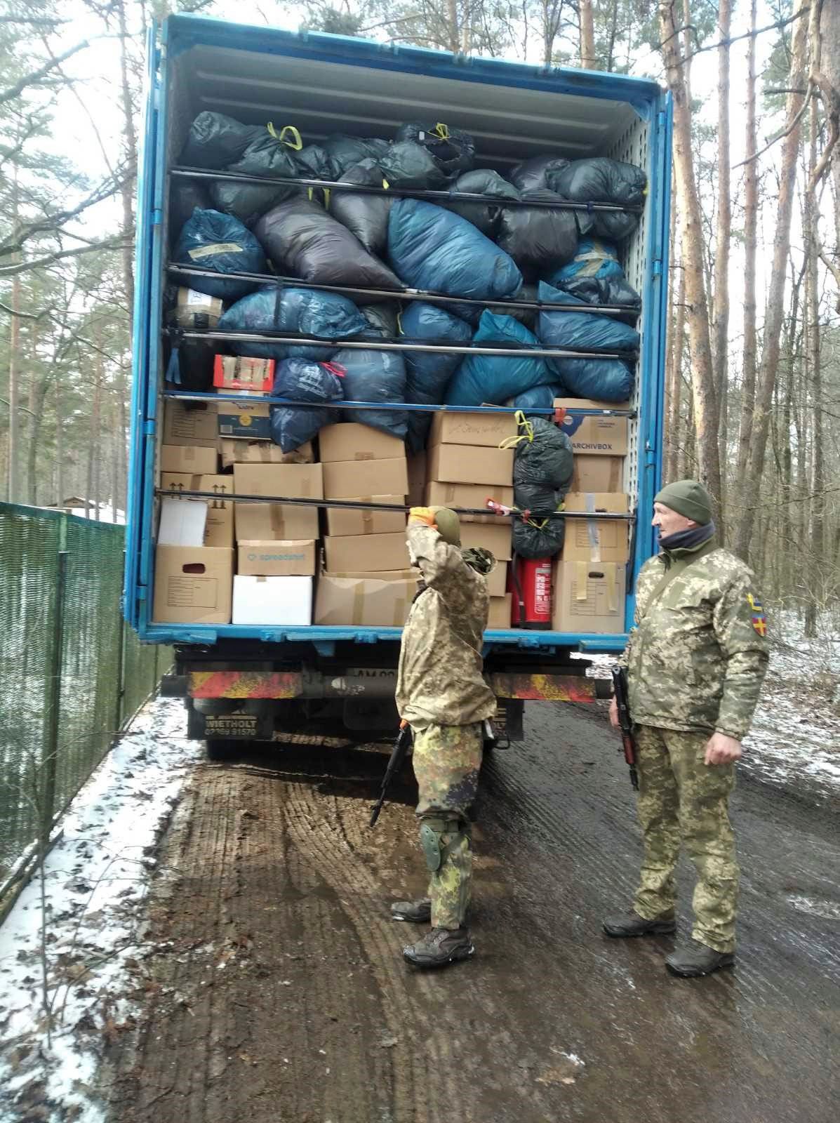 Zwei Soldaten stehen neben einem Lastwagen voller Kisten und Taschen.