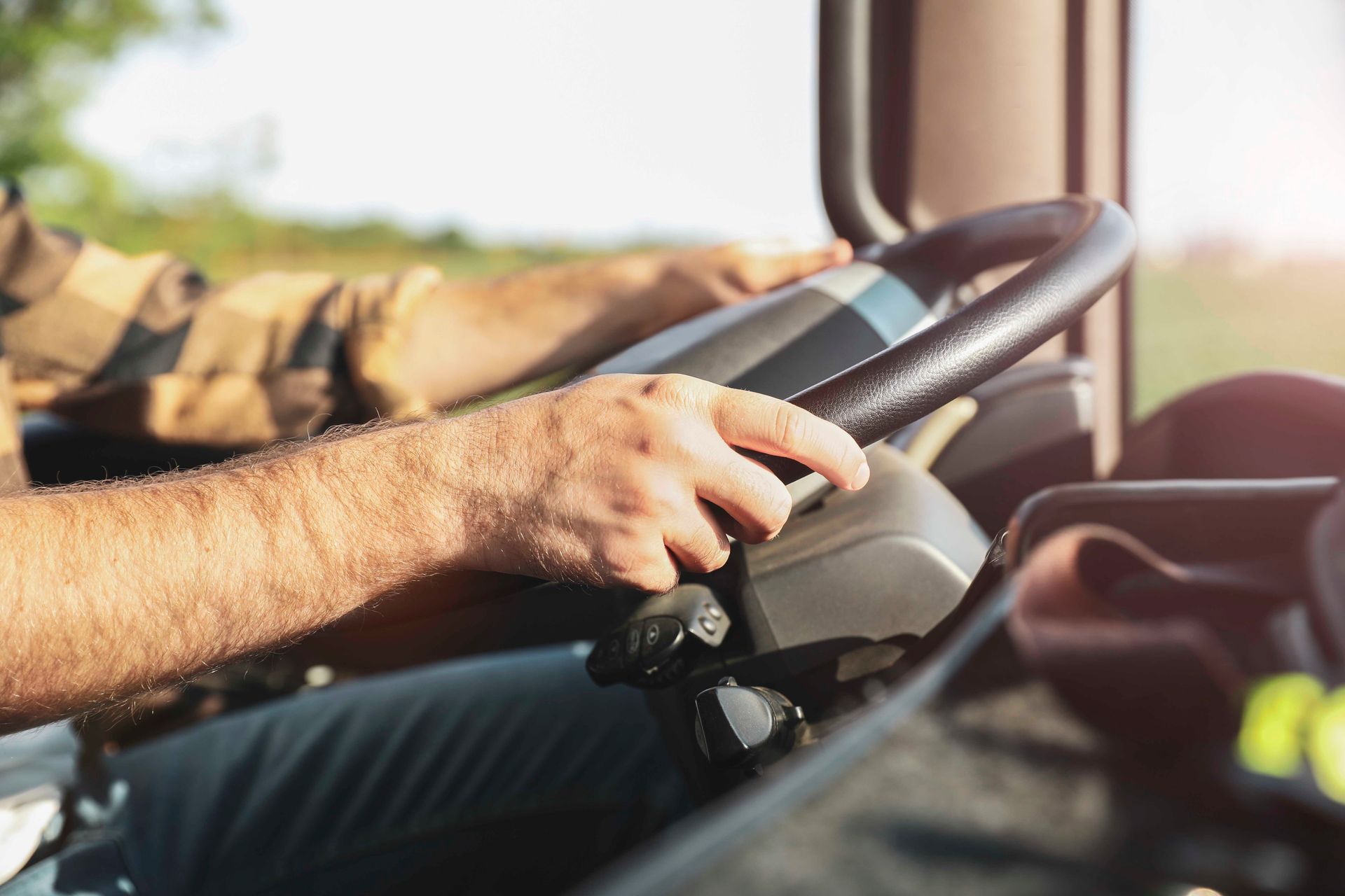Ein Mann fährt einen LKW auf einer Autobahn und hält dabei das Lenkrad in der Hand.