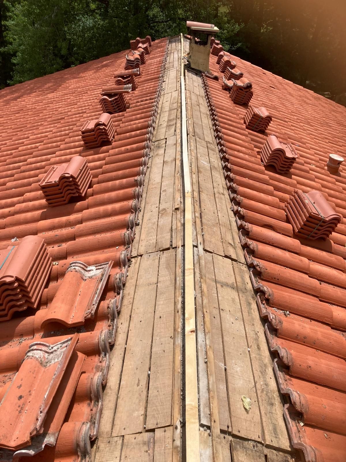 Toit de tuiles en terre cuite rouge avec une passerelle en bois au centre