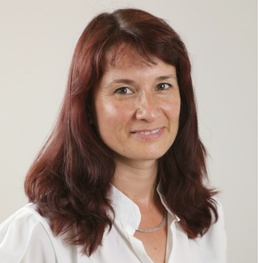 Eine Frau mit langen roten Haaren trägt ein weißes Hemd