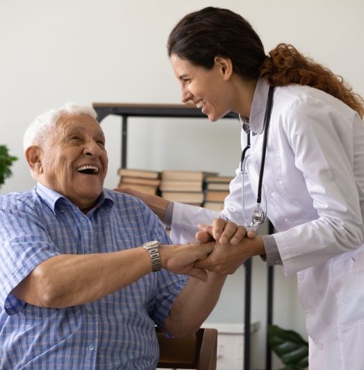 Eine Krankenschwester schüttelt einem älteren Mann die Hand.