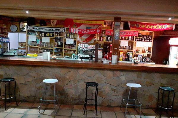 Una barra con taburetes y un cartel que dice 'Coca Cola'.