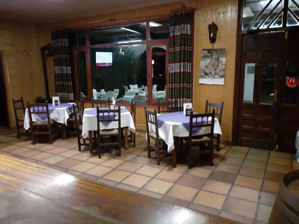 Un restaurante con mesas y sillas y un televisor en la pared.