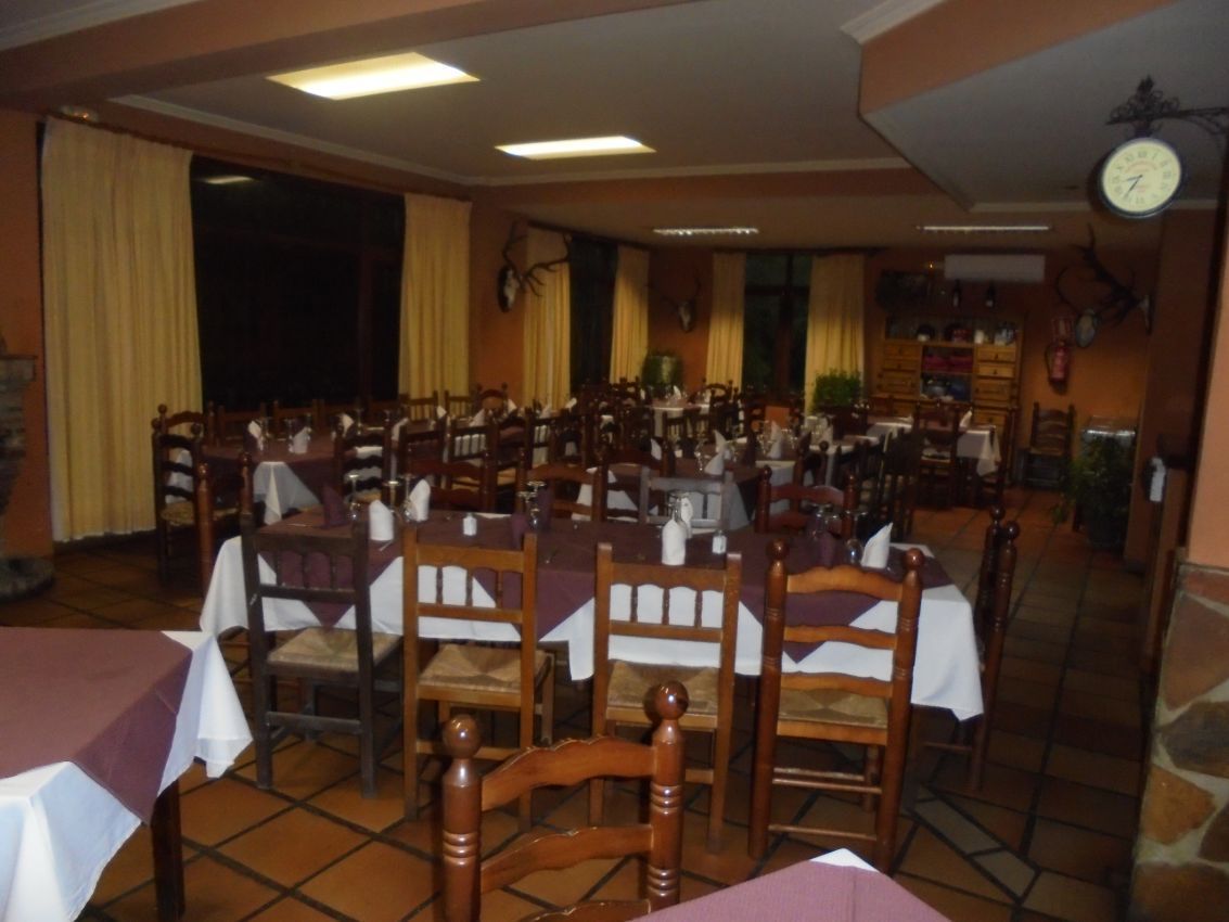 Un restaurante con mesas y sillas y un reloj en la pared.