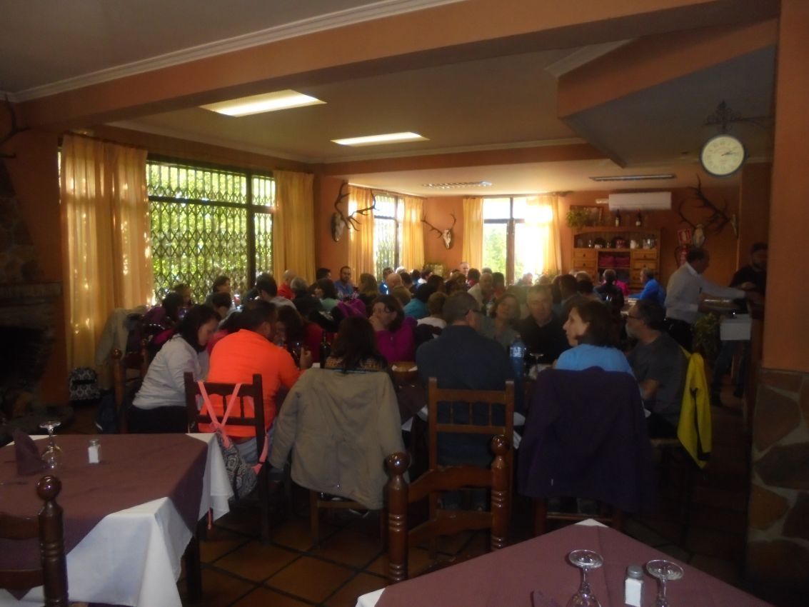 Un grupo grande de personas están sentadas en mesas en un restaurante.
