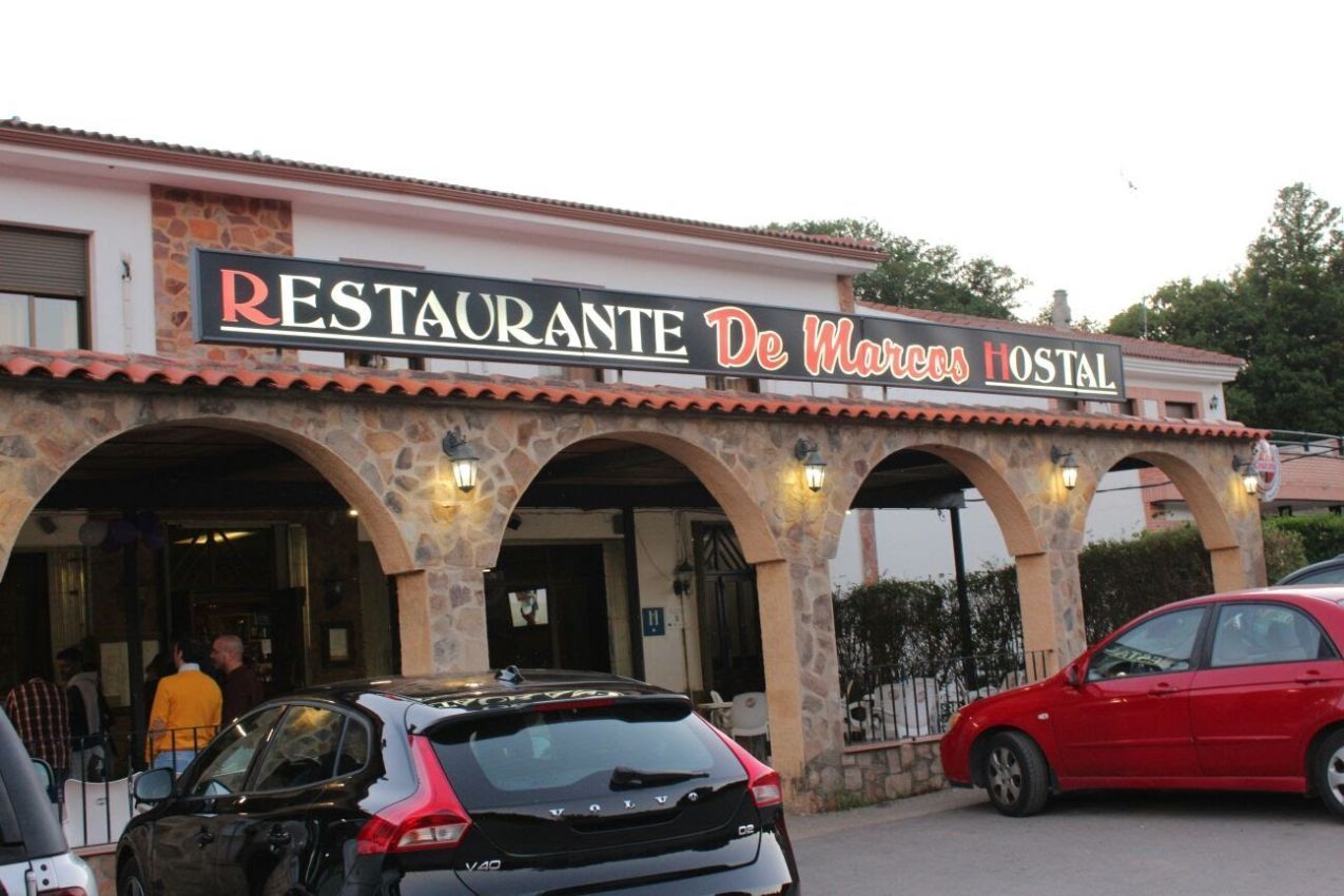 Un restaurante con coches aparcados delante.