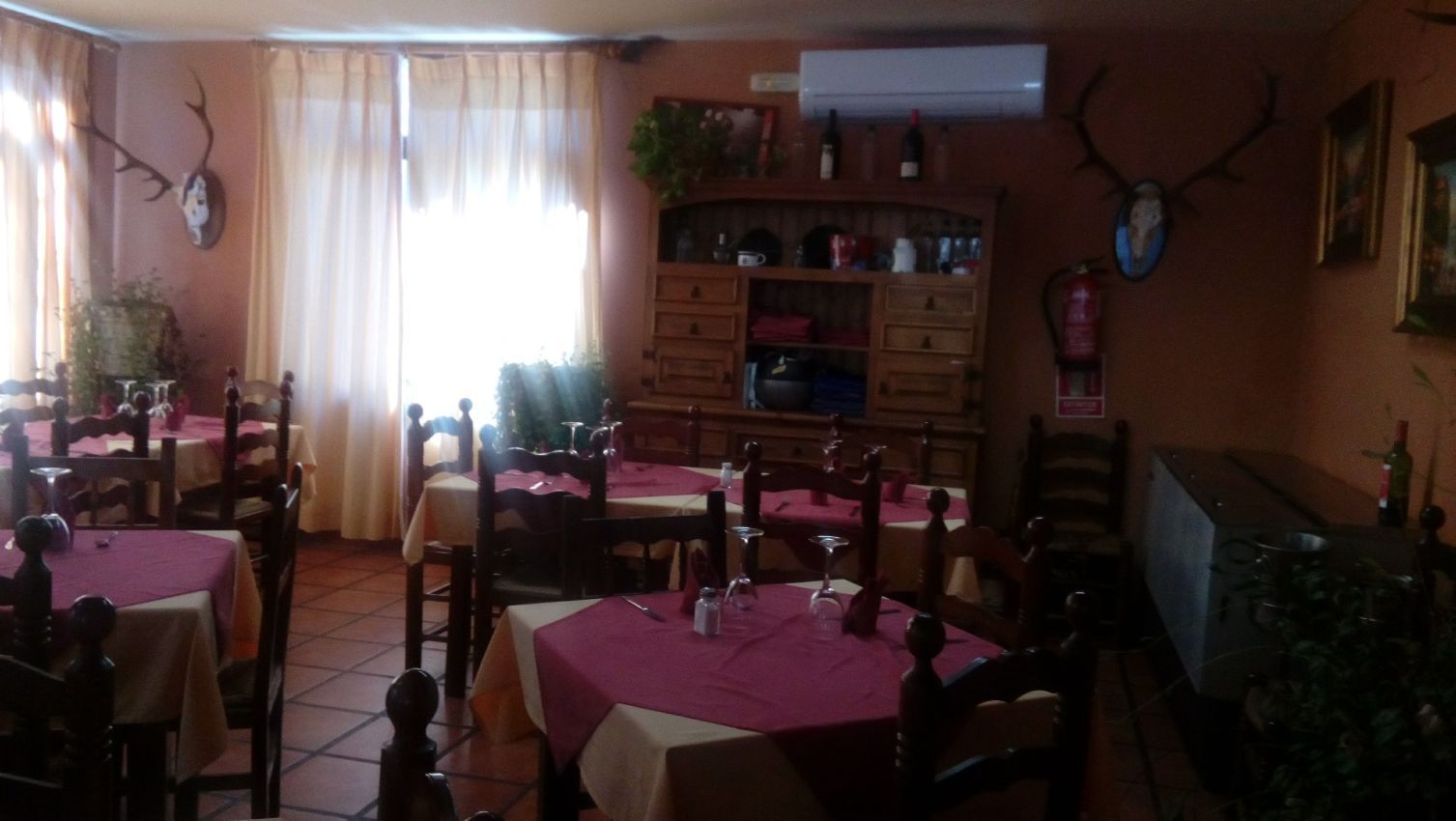 Un restaurante con mesas y sillas y astas en la pared.