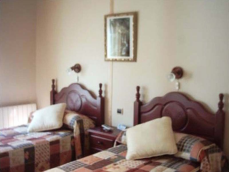 Un dormitorio con dos camas y un cuadro en la pared.