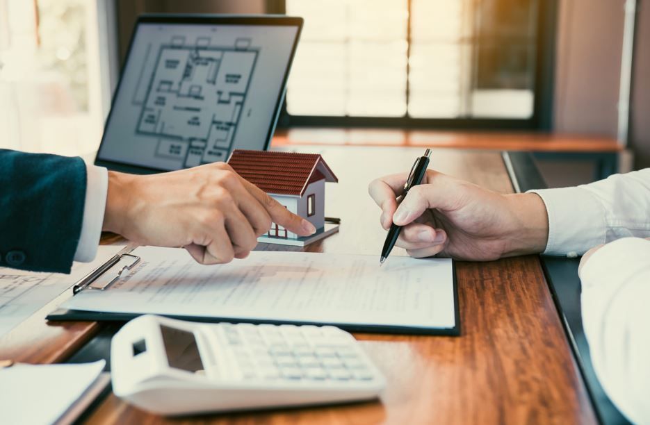 Dos personas firman un documento inmobiliario