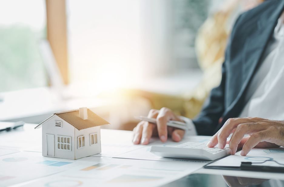 Una persona vestida con traje de negocios utiliza una calculadora