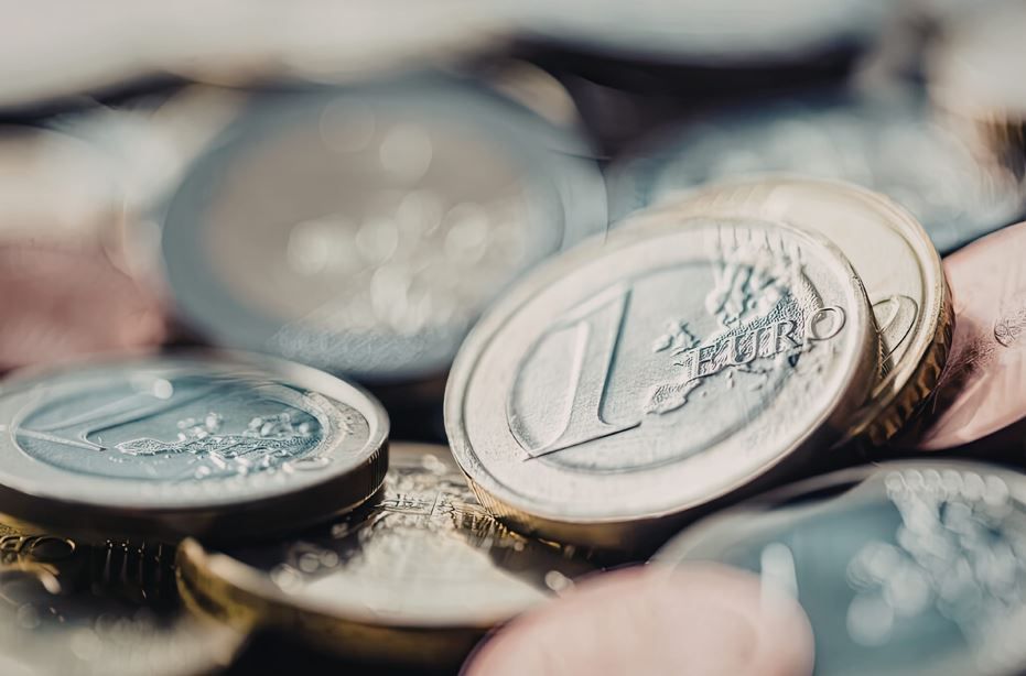 Primer plano de una pila de monedas europeas de un euro con tonos plateados y dorados metálicos.
